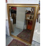 A gilt and silvered coloured framed wall mirror with rectangular mirrored plate 135cm x 103cm