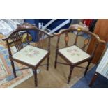 A matched pair of Edwardian mahogany corner armchairs having Sheraton revival inlaid and turned