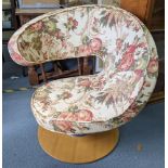 A vintage Peel swivel chair having floral upholstery and on a light wood base Location: