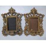 A pair of Victorian gilt metal picture frames decorated with floral scrolls and having easel backs