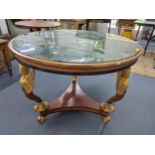 An Empire style circular topped table having a marble effect top, supported by three winged angels