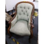 A Victorian rosewood button, spoonback armchair having scrolled arms and two front cabriole legs,