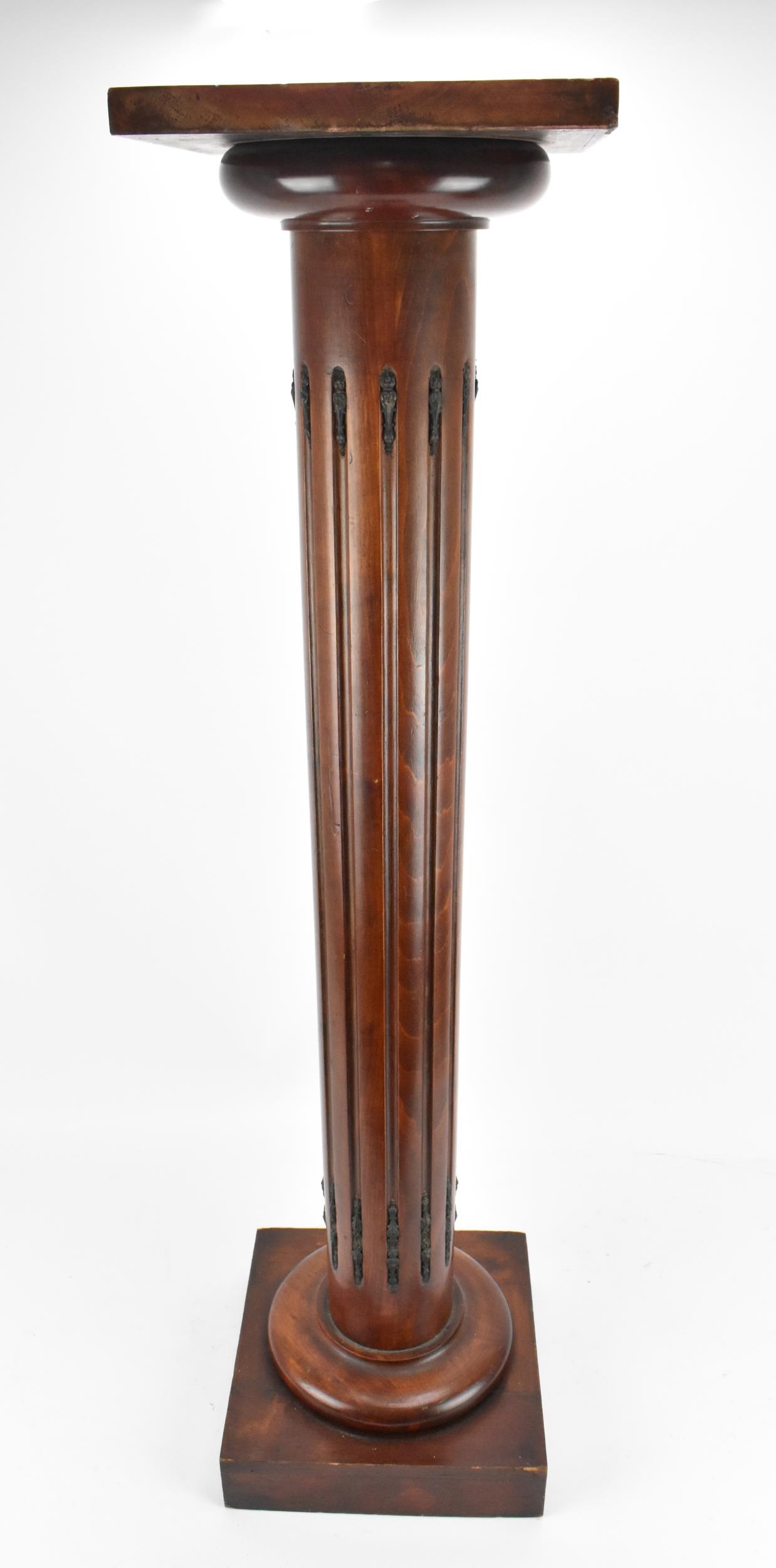 A brass-mounted wooden column pedestal, with flat platform top and fluted column support, 106 cm