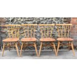 A set of four Ercol candlestick back dining chairs, in light beech and elm, on tapering legs