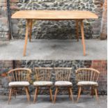 A mid century light elm Ercol dining table and chairs, the table of rectangular form with tapering