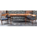 A teak G-plan oval table with a set of four G-plan dining chairs with black leatherette seats, the