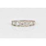 An 18ct white gold seven stone diamond half eternity ring, the pave set round brilliant cut stones