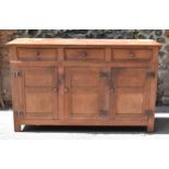 A Heals limed oak sideboard, circa late 1930s, designed with forged iron exposed cabinet door