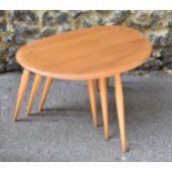 A nest of three Ercol elm and beech pebble tables, largest 40 cm high x 64 cm wide