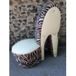 A contemporary bedroom chair in the form of a stiletto shoe having faux cream leather and animal