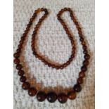 A long string of vintage graduating amber beads. Location:Cab