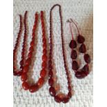 An amber necklace of 29 graduating beads together with 3 vintage necklaces of red faceted resin