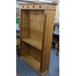 A modern pine open bookcase having a stepped cornice and a plinth base, 181.5cm h x 120.5cm w