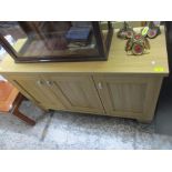 A modern Woodbury Bros birchwood effect sideboard, three fielded cupboard doors with grey painted