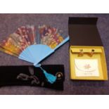 A modern blue treen and printed paper fan with a Duvelleroy of Paris fan fabric case together with