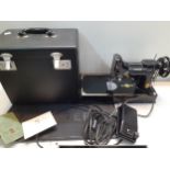 A 1952 Singer Featherweight 221K1 portable electric sewing machine in case with accessories,