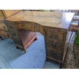 A mid 20th century walnut desk having a central bow drawer flanked by six drawers 74cm h x 108 cm