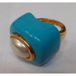 Kenneth Jay Lane- A contemporary gold tone ring having an oval pearlised cabochon on a turquoise