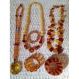 A group of vintage amber and amber effect necklaces and bracelets. Location:Cab