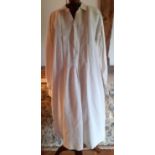 A 20th Century cream linen farmer's smock with pleats to the front and a small embroidered