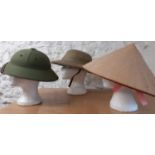 A Vietnam style green pith helmet together with a 1986 Raffles Hotel 100th Anniversary light khaki