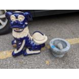 A large Chinese pottery model of a foo dog, 46cm high and a granite style pestle and mortar
