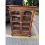 An Asian hardwood cabinet with twin glazed doors over two drawers Location: