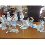 A group of Lladro porcelain figurines to include clow figurines, a model of a donkey and others.