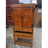 A 20th century Chinese elm two part cabinet with a pair of doors, over two drawers Location: