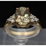 A 9ct gold yellow topaz oval cut ring flanked by three diamonds to each shoulder, 2.3g Location: