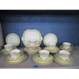 Aynsley porcelain tea set, pale yellow ground, green and gilt border, comprising 33 pieces.