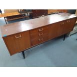 A Nathan retro sideboard having two cupboard doors, three drawers and a fall flap, 77.5cm h x