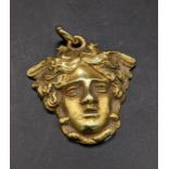 A yellow metal pendant in the form of a classical mask, tested as 22ct, total weight 6.3g Location: