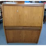 A vintage Remploy teak bureau having a fall flap above two drawers and two cupboard doors 110.5cm