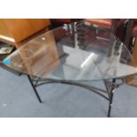 A contemporary triangular glass coffee table on metal supports Location: A1F