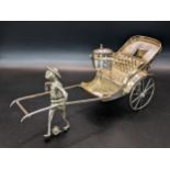 A white metal Chinese cruet stand in the form of a Rickshaw being pulled by a man, 189.1g Location: