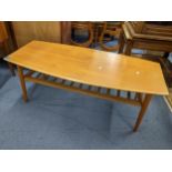 A vintage teak coffee table having a magazine rack and circular tapering legs 46cm h x 120cm w