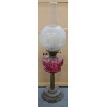 A Victorian brass oil lamp having an etched shade and cranberry glass reservoir, Location: