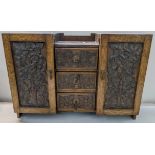 An early 20th century oak wall hanging table top cabinet having carved panelled doors flanking three