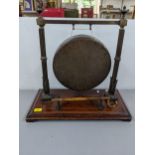 A Burmese brass table gong mounted on an oak base Location: