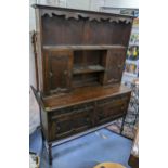 A 1930s oak dresser having a moulded cornice above open shelves, two drawers and two cupboards 192cm