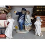 A large Nao figurine of a sailor and a child, a small Lladro figure of a child in a bathrobe and a