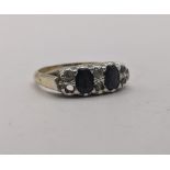 A yellow gold and silver set ring set with two black coloured stones between three vertical rows