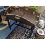 A reproduction mahogany butlers tray topped coffee table with hinged sides and on square moulded