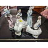 A group of Lladro and Nao porcelain figurines, along with two Lladro dove models, and a Japanese