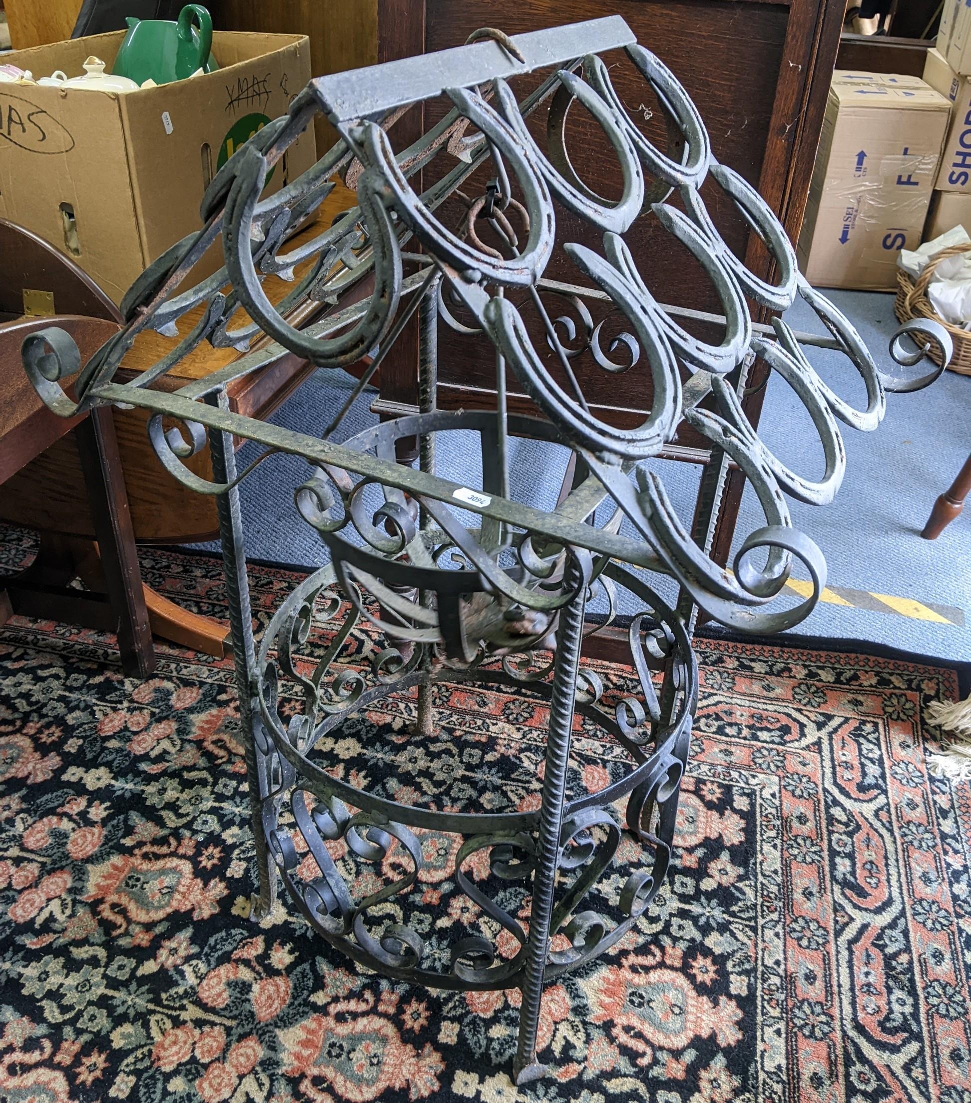 A wrought iron garden centrepiece with central hanging basket, the top made from horseshoes 84cm h x
