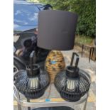 A pair of black painted Chinese bamboo lanterns with candles and a ceramic gilt and black lamp