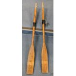 A pair of vintage rowing oars 147.5cm long together with a bow and arrows and a partial vintage bow.