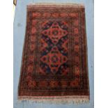 A Persian hand woven rug having a red ground, two motifs and multiguard borders, 152cm x 99cm