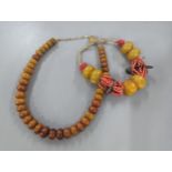 An amber beaded necklace having graduating beads, together with one other similar having coral,